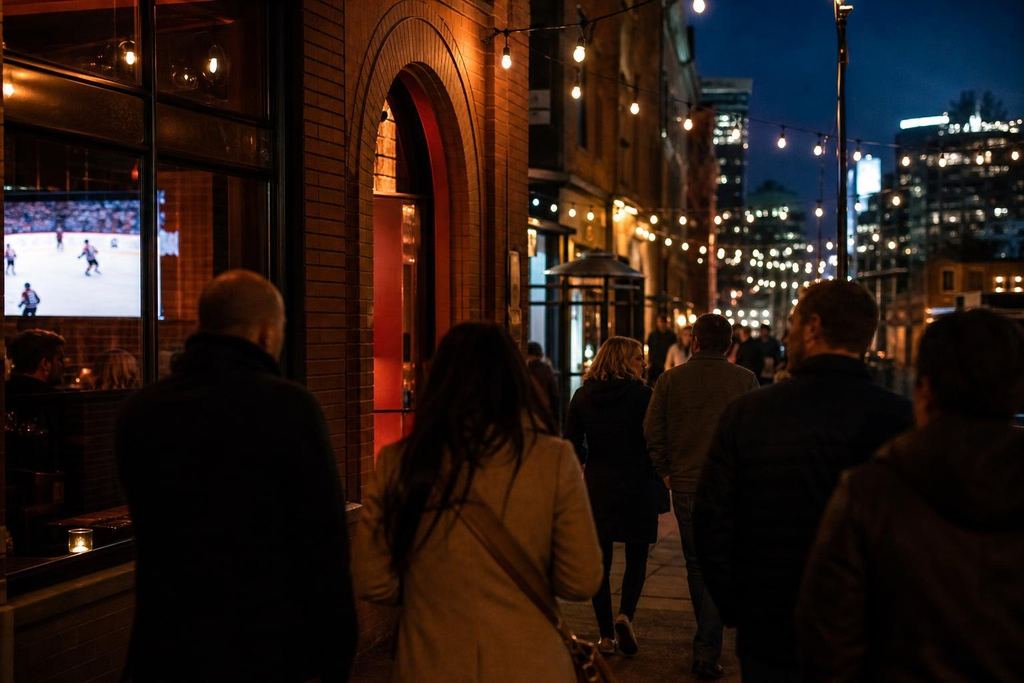Friends walking between bars on a chilly autumn evening past brick buildings and string lights (AI-generated image)