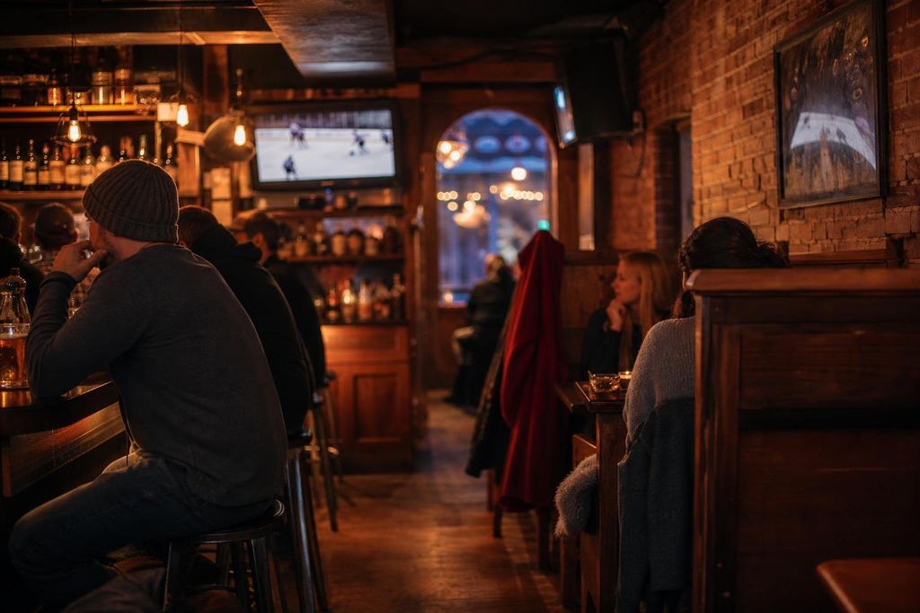 A cosy brick-walled side-street pub with wooden booths and a small TV over the bar (AI-generated image)